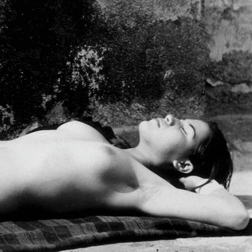 Fotografia en blanco y negro de mujer desnuda acostada sobre una manta con las manos en las nuca de Manuel Alvarez Bravo titulada La buena fama durmiendo 1939